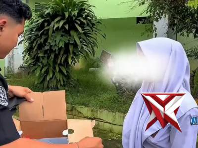 Personel Humas Polres Kudus memberi bantuan hrlam kepada anak-anak sekolah