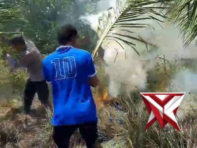 Personil Polsek Nuangan Membantu Warga Memadamkan Api di Kebun Kelapa Warga - PoliceTube
