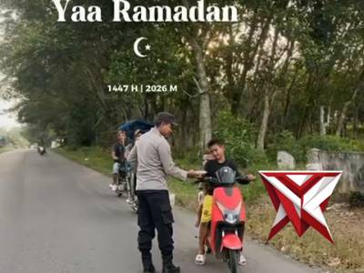 Anggota polsek Buay Pemuka Peliung membagikan takjil kepada pengendara yang lewat di sekitar pos-pol