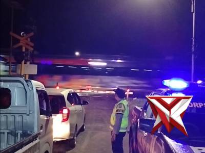 Petugas Polsek Kartoharjo Magetan laksanakan patroli  di perlintasan rel kereta api