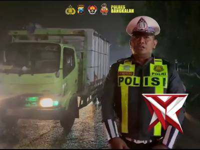Personil Pos Yan Suramadu Polres Bangkalan melaksanakan pengaturan Lalu lintas pada malam hari.