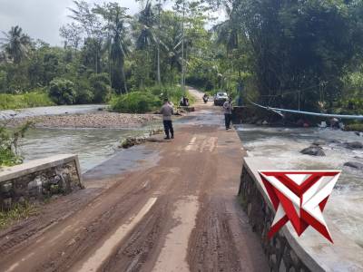 KAPOLSEK DAN ANGGOTA SEDANG BERSIHKAN SAMPAH YANG MENYANGKUT DI JALAN PERLINTASAN
