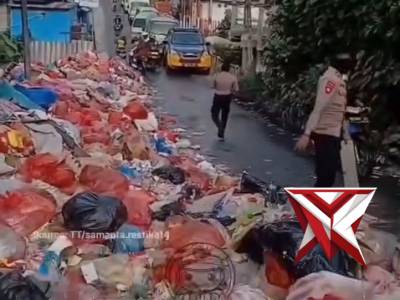 Polri membantu membersihkan sampah yang menumpuk di jalan raya
