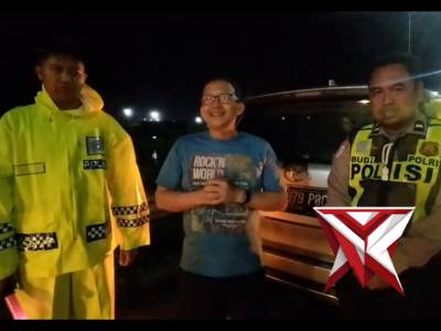 Petugas Pos Pam Exit Tol Ngawi membantu seorang pemudik yang mengalami pecah ban