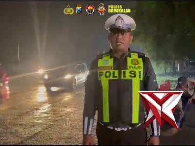 Personil Pos Yan Suramadu Polres Bangkalan melaksanakan pengaturan Lalu lintas pada malam hari.