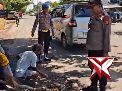 Kapolsek tugumulyo beserta anggota laksanakan giat penimbunan jalan berlubang