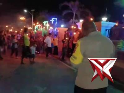 Bhabinkamtibmas melaksanakan giat pengamanan jalan obor paskah malam puji pujian di negeri kariu