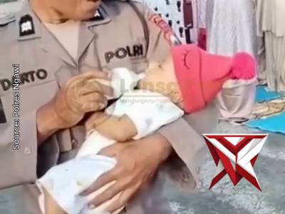 Polisi Gendong Balita Saat Salat Ied.