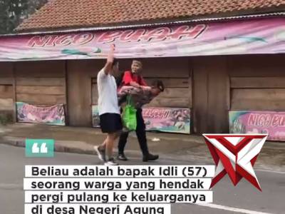 Seorang anggota polres oku selatan membantu bapak bapak yang sedang duduk di jalan