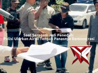 seorang anggota kepolisian membagikan air mineral kpd massa aksi yg kelelahan ditengah terik pana