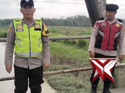 Personil Polsek Belitang I melaksanakan giat Mitigasi Bencana Alam pengecekan debit Air